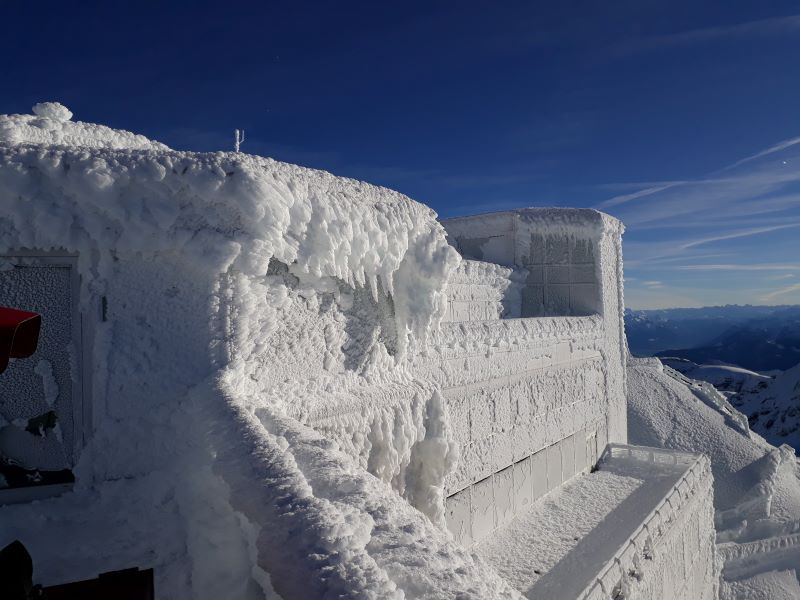 Der Säntis ist bekannt als Berg der Wetterrekorde. Das Gipfelgebäude komplett in Eis gekleidet. Die Wettermessstation (rechts) wurde vom Eis stillgelegt (Bild: Säntis-Schwebebahn AG)..